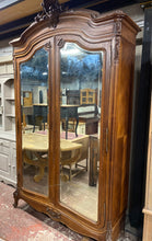 Load image into Gallery viewer, Indulge in the beauty of this remarkable French-inspired armoire: strong, functional, and overall in great condition. While some minor damage is present, it does not hinder its usefulness. Featuring 2 beautiful beveled mirrors on the doors, 2 drawers at the base, and a hanging rail, this armoire can be easily disassembled for convenient transportation.  

