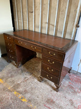 Load image into Gallery viewer, This lovely double pedestal oak veneer desk is structurally sound. It does have a fair few marks and scratches but nothing too major. The leather inlay is in good condition. This item has plenty of storage with 8 short dovetail jointed drawers and 1 long. Comes complete with key.   Overall Dimensions  143cm wide x 66cm deep x 77cm high 
